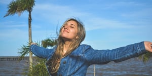 A woman with her arms outstretched and happy.