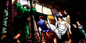 A stain glass depiction ofJesus being carried from the tomb.