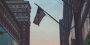 An American flag flying over buildings. 