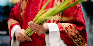 A priest holding a palm leaf.