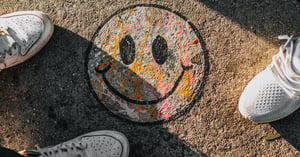 A vibrant smiley face drawn on a sidewalk exhibiting positive emotions