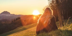 A woman sitting in a field. 