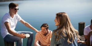 A group of young people on a pier talking.