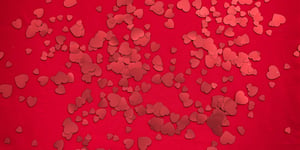A red table with red heart confetti.