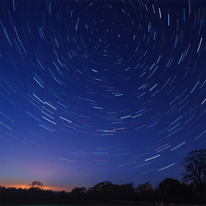 stars and light trails over the horizon