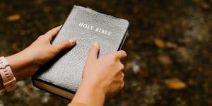 A person holding a bible. 